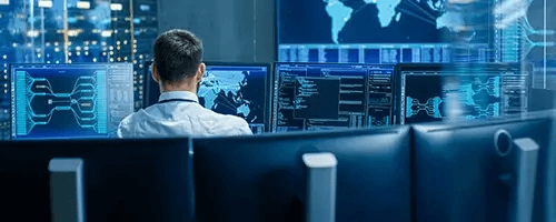 A person looking at multiple computer screens